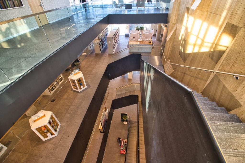 Looking down on a staircase through four floors of a public library.