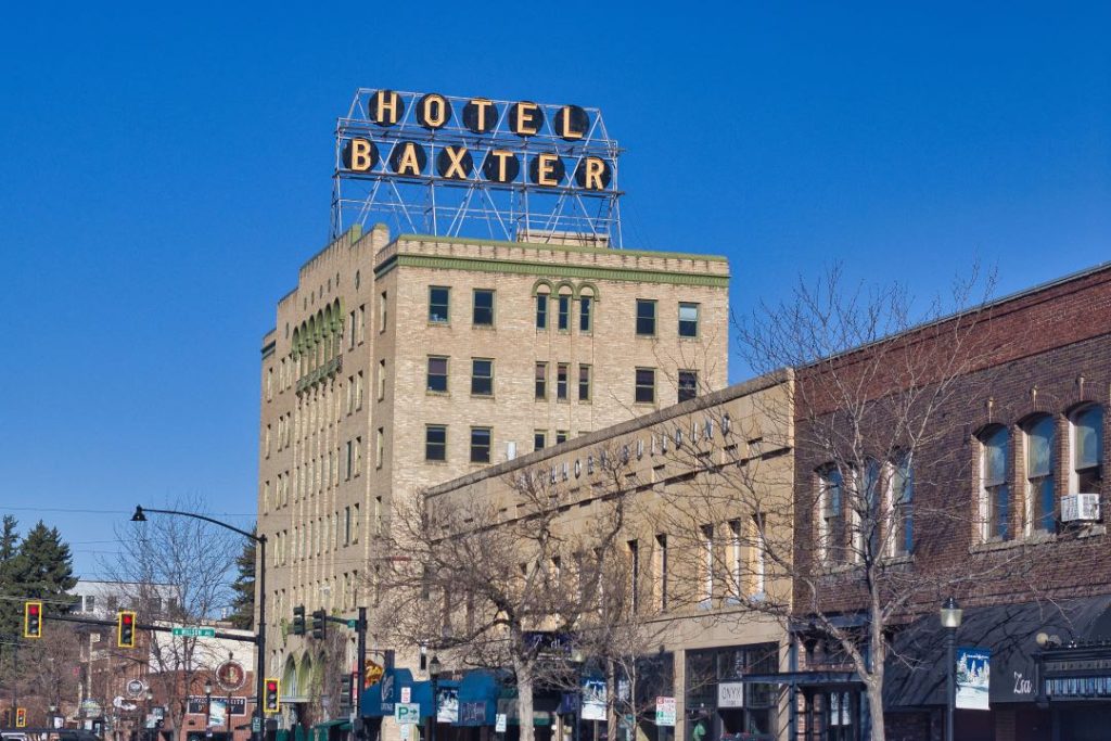 A large multistory brick building with a marquee sign of above saying "Hotel Baxter".