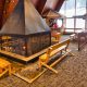 A fireplace surrounded by log benches in a ski lodge