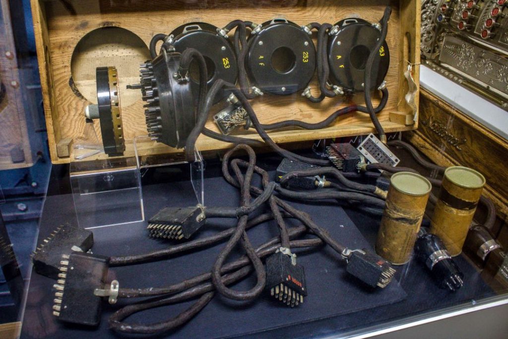 A glass case at a museum filled with antique electronics.