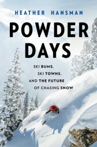 The cover of a book that says in black text "Powder Days" and the authors name, Heather Hansman, in blue text. There is also an image of a skier in a red jacket going down a steep ski hill.