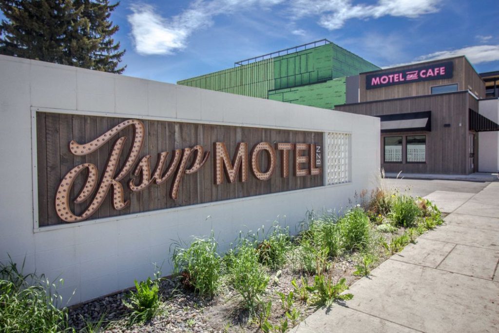 A sign in marquee lights says RSVP Motel against a white background.