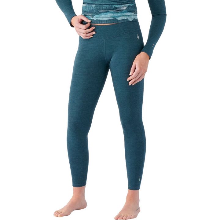 The bottom half of a white woman wearing teal leggings.